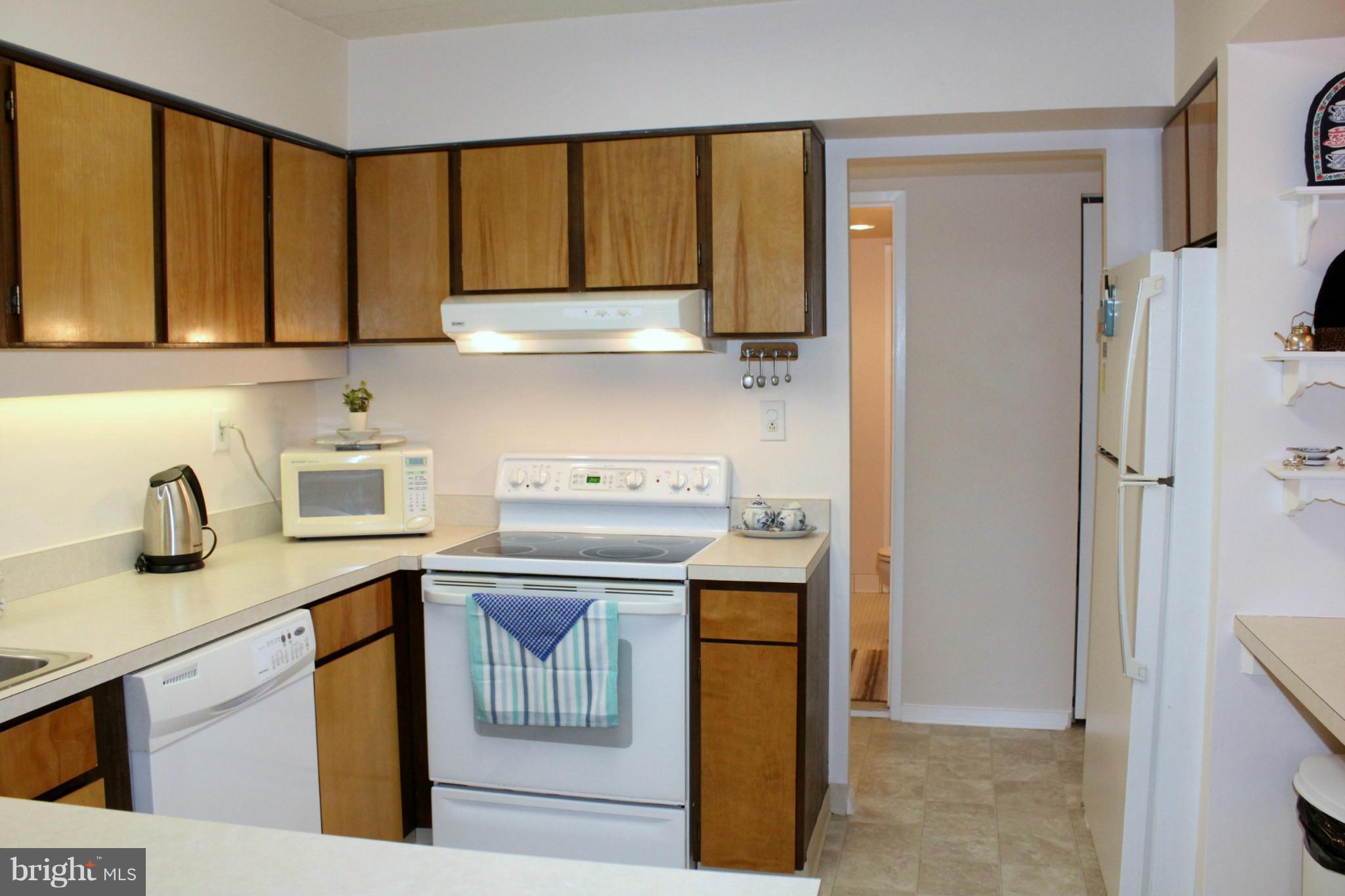 5643 Harpers Farm Road, Unit A Columbia, MD 21044 - Photo 6 of 25 a kitchen with stainless steel appliances granite countertop a sink stove and refrigerator