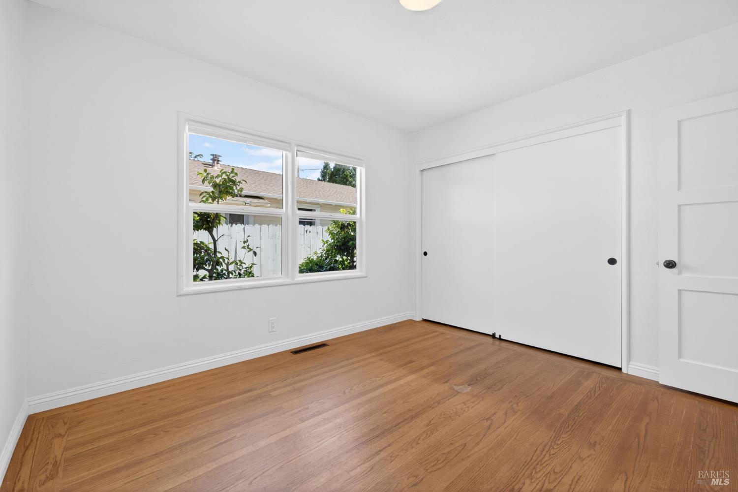 2211 Humboldt Street Santa Rosa, CA 95404 - Photo 32 of 52 a view of an empty room with wooden floor and a window