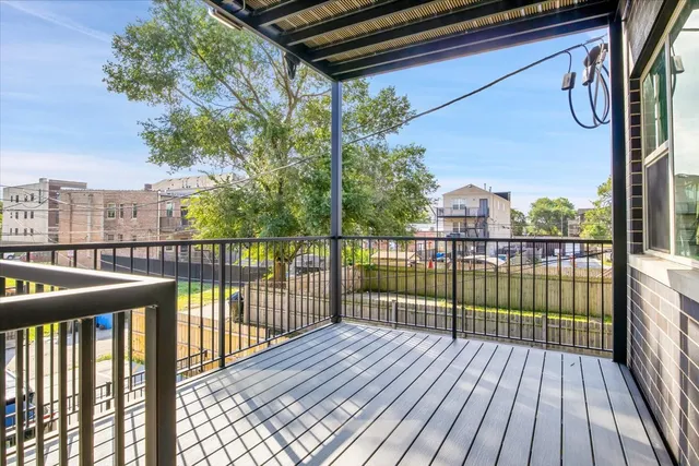 a view of a balcony with wooden floor and fence