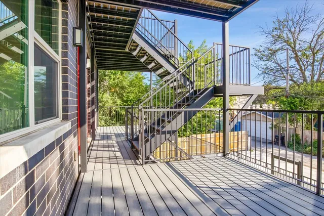 a view of balcony with wooden floor and fence and a potted plant