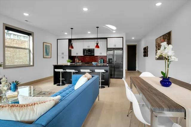 a kitchen with stainless steel appliances kitchen island granite countertop a sink dishwasher stove and refrigerator