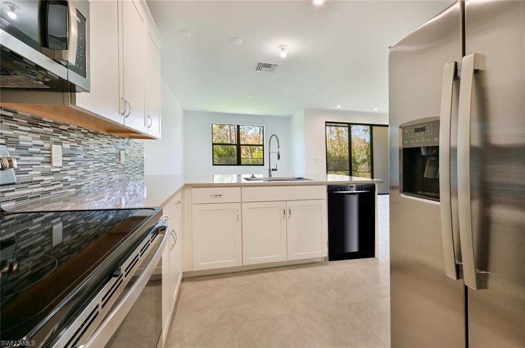 7611 Morgan Way Naples, FL 34119 - Photo 7 of 26 a kitchen with a stove and a refrigerator