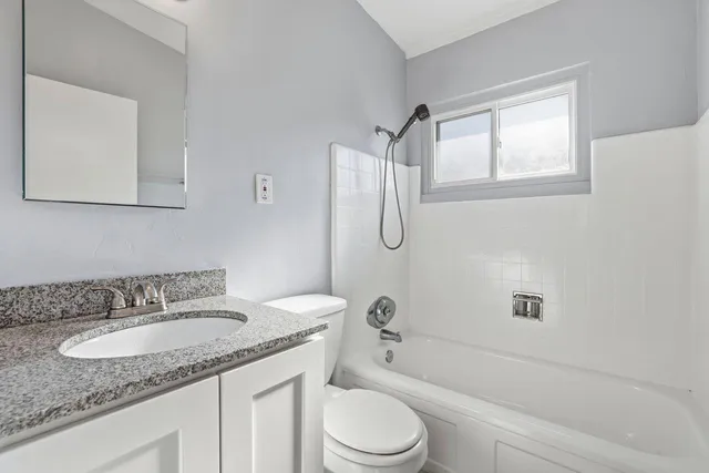 a bathroom with a granite countertop sink toilet and shower