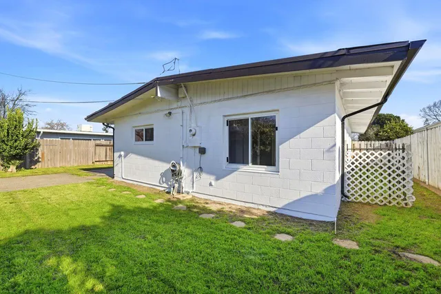 a backyard of a house with table and chairs