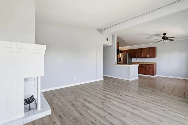 a view of empty room with wooden floor and fireplace