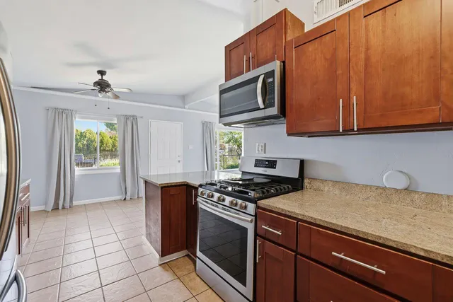 a kitchen with stainless steel appliances granite countertop a stove a sink and a microwave