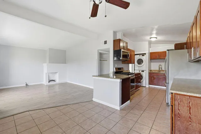 a kitchen with stainless steel appliances kitchen island granite countertop a refrigerator and a stove