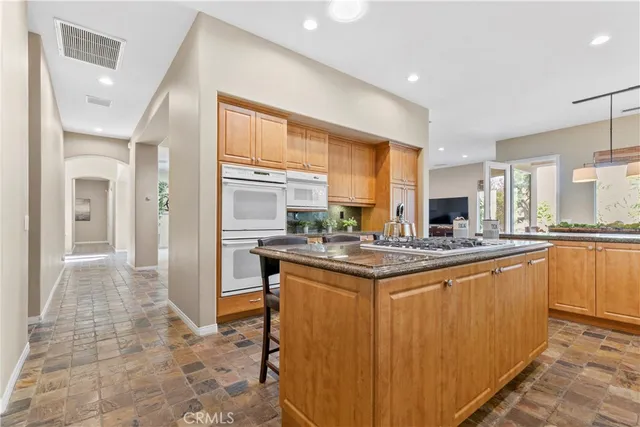 a kitchen with a dining table chairs and large windows