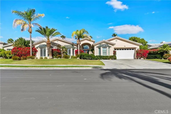 a front view of a house with a yard and potted plants
