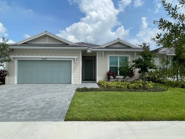 a front view of a house with a garden and yard