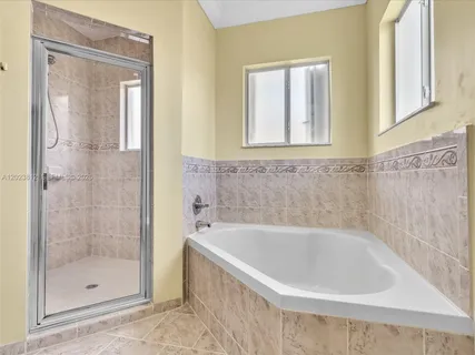 a white bath tub sitting next to a shower