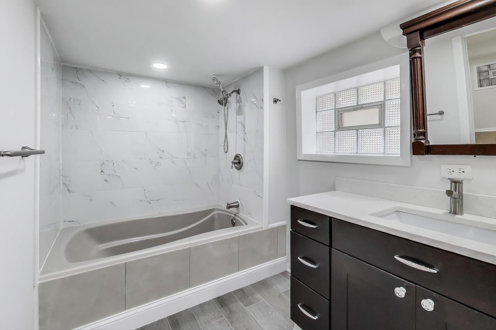 4118 Prairie Avenue Brookfield, IL 60513 - Photo 33 of 43 a bathroom with a tub sink vanity granite and a mirror