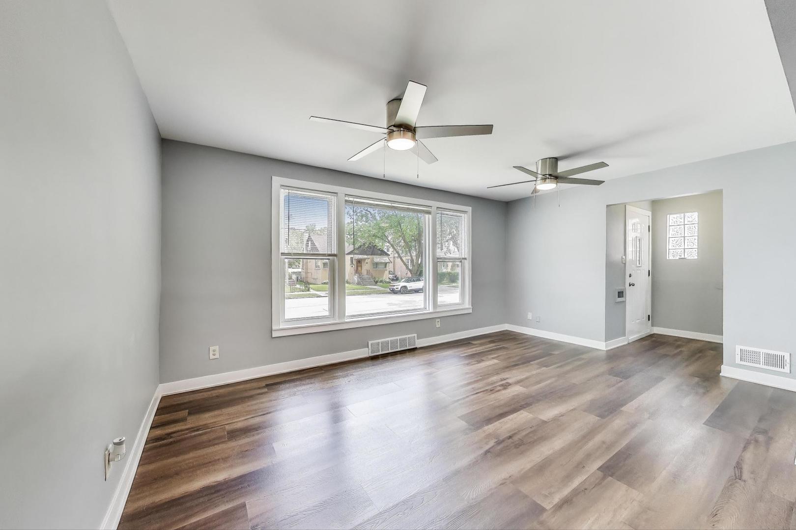 4118 Prairie Avenue Brookfield, IL 60513 - Photo 6 of 43 an empty room with wooden floor chandelier fan and windows