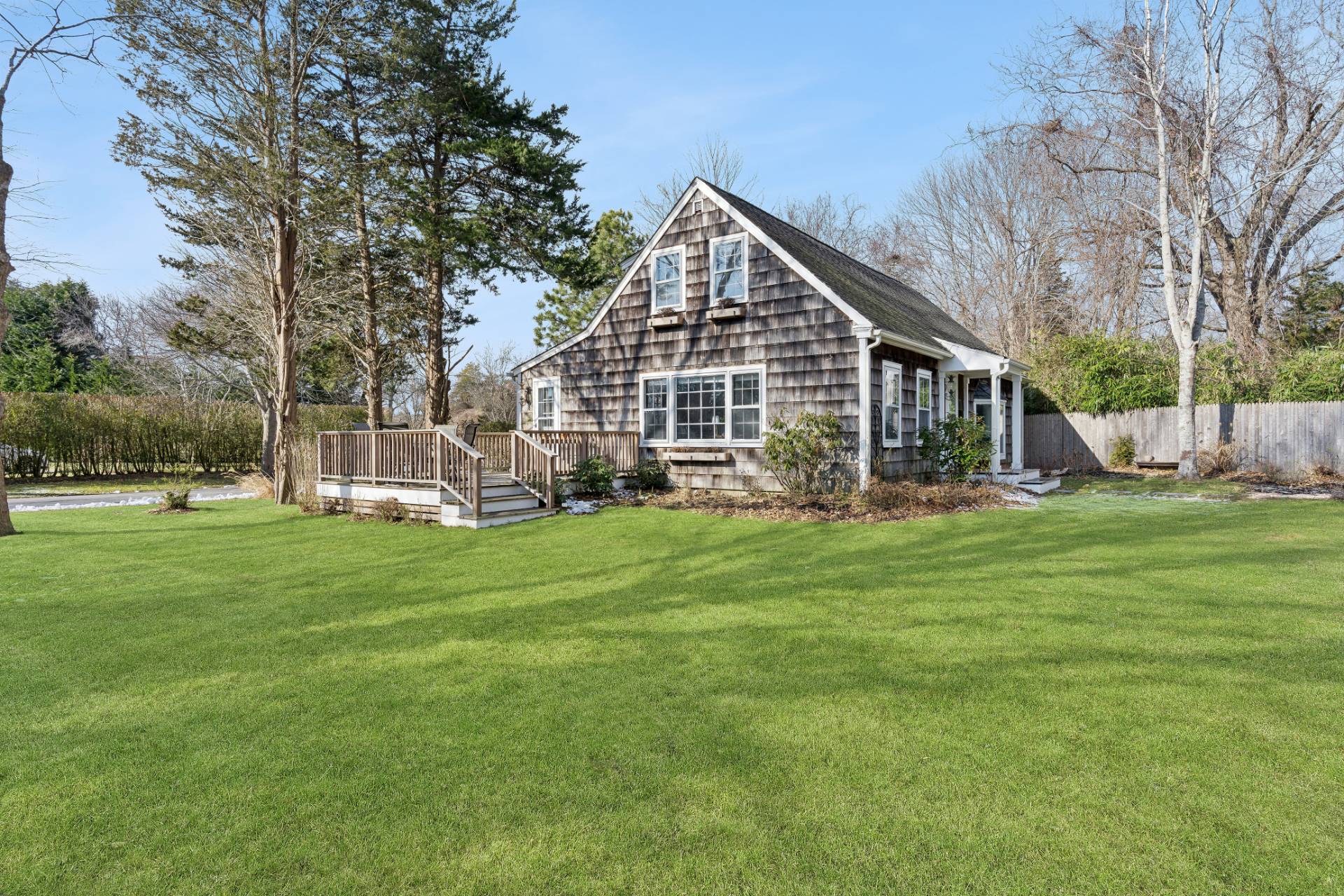 144 Sayre's Path Wainscott, NY 11975 - Photo 1 of 8 a front view of house with a garden and trees