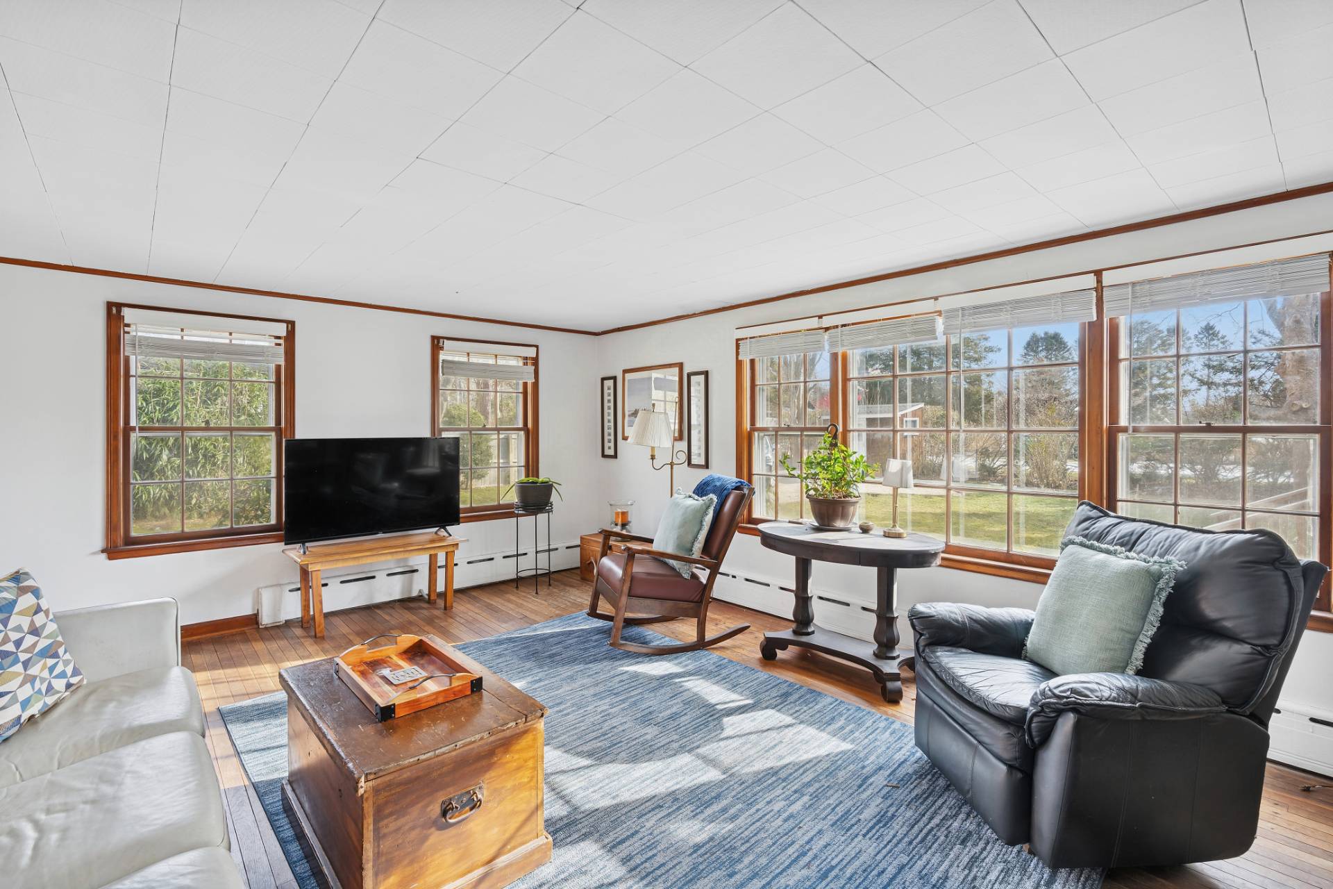 144 Sayre's Path Wainscott, NY 11975 - Photo 2 of 8 a living room with furniture a flat screen tv and a floor to ceiling window