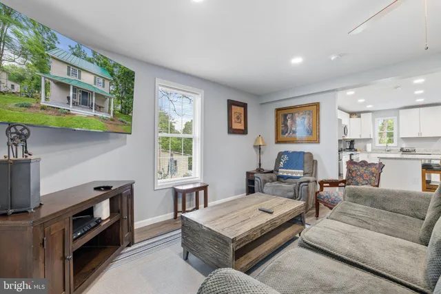 a view of a hallway with bathroom and wooden floor
