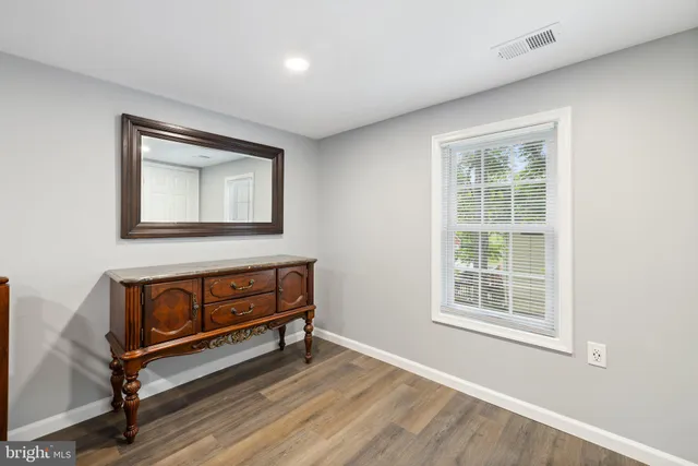 a kitchen with stainless steel appliances granite countertop a stove top oven a sink a dining table and chairs with wooden floor