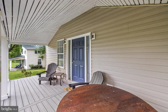 a balcony with wooden floor table and chairs