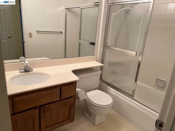 a bathroom with a sink a toilet a mirror and shower