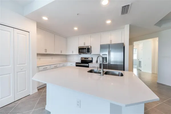a kitchen with granite countertop a refrigerator and a sink