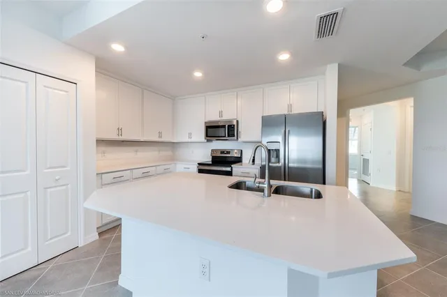 a kitchen with granite countertop a refrigerator and a sink