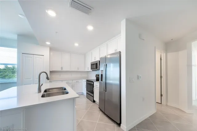 a kitchen with stainless steel appliances granite countertop a sink a refrigerator and a stove