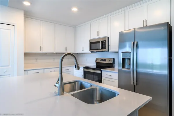 a kitchen with stainless steel appliances a refrigerator sink and microwave