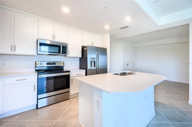 a kitchen with kitchen island a stove sink and microwave