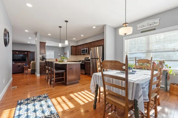 a kitchen with stainless steel appliances kitchen island granite countertop a dining table chairs and stove top oven