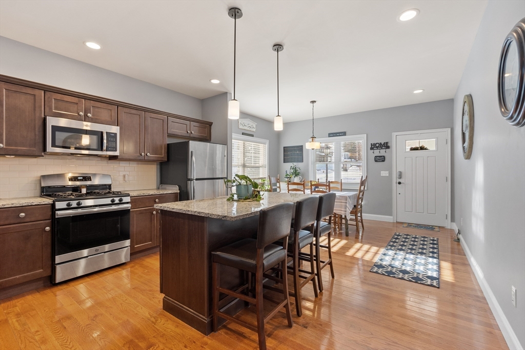 2 Eagle Nest Road, Unit B62 Clinton, MA 01510 - Photo 4 of 35 a kitchen with stainless steel appliances granite countertop a stove a refrigerator a kitchen island a sink a stove a dining table and chairs
