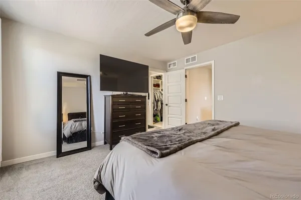 a bedroom with a bed and a ceiling fan