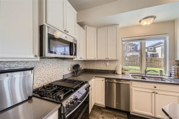 a kitchen with stainless steel appliances a sink a stove a microwave and cabinets