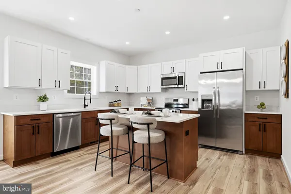 a kitchen with kitchen island granite countertop wooden cabinets and stainless steel appliances