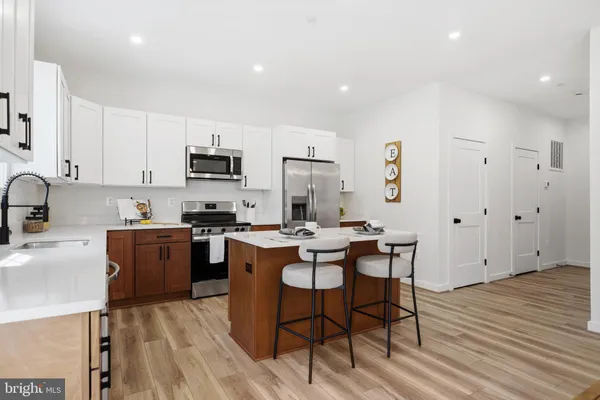 a kitchen with a sink a microwave a stove and cabinets
