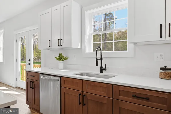 a kitchen with stainless steel appliances a sink a window and cabinets