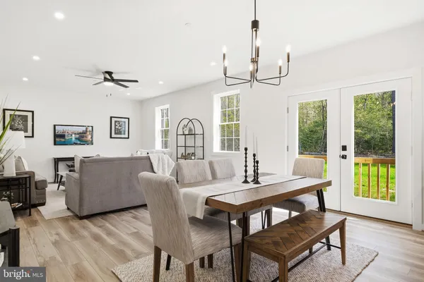 a living room with furniture a large window and a chandelier