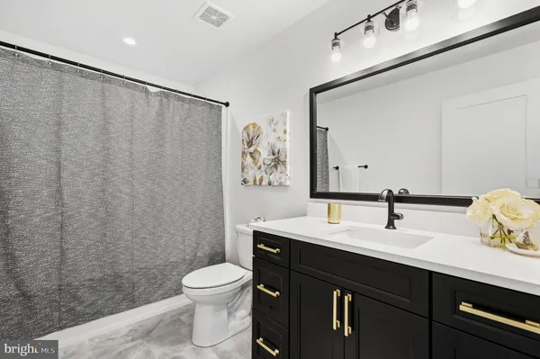 a bathroom with a toilet a sink and a mirror