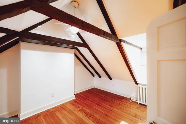 a view of staircase with wooden floor and white walls