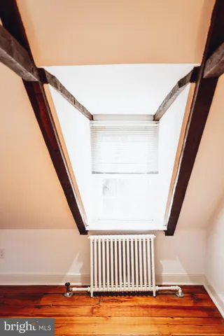 a view of an empty room with wooden floor and door