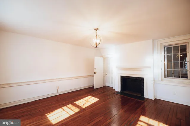 a view of a livingroom with wooden floor and a fireplace