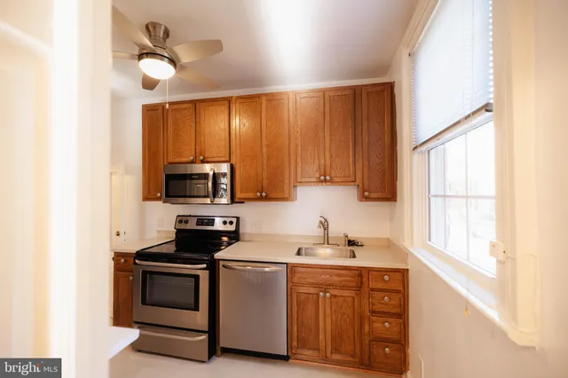 a kitchen with stainless steel appliances a stove a sink and white cabinets