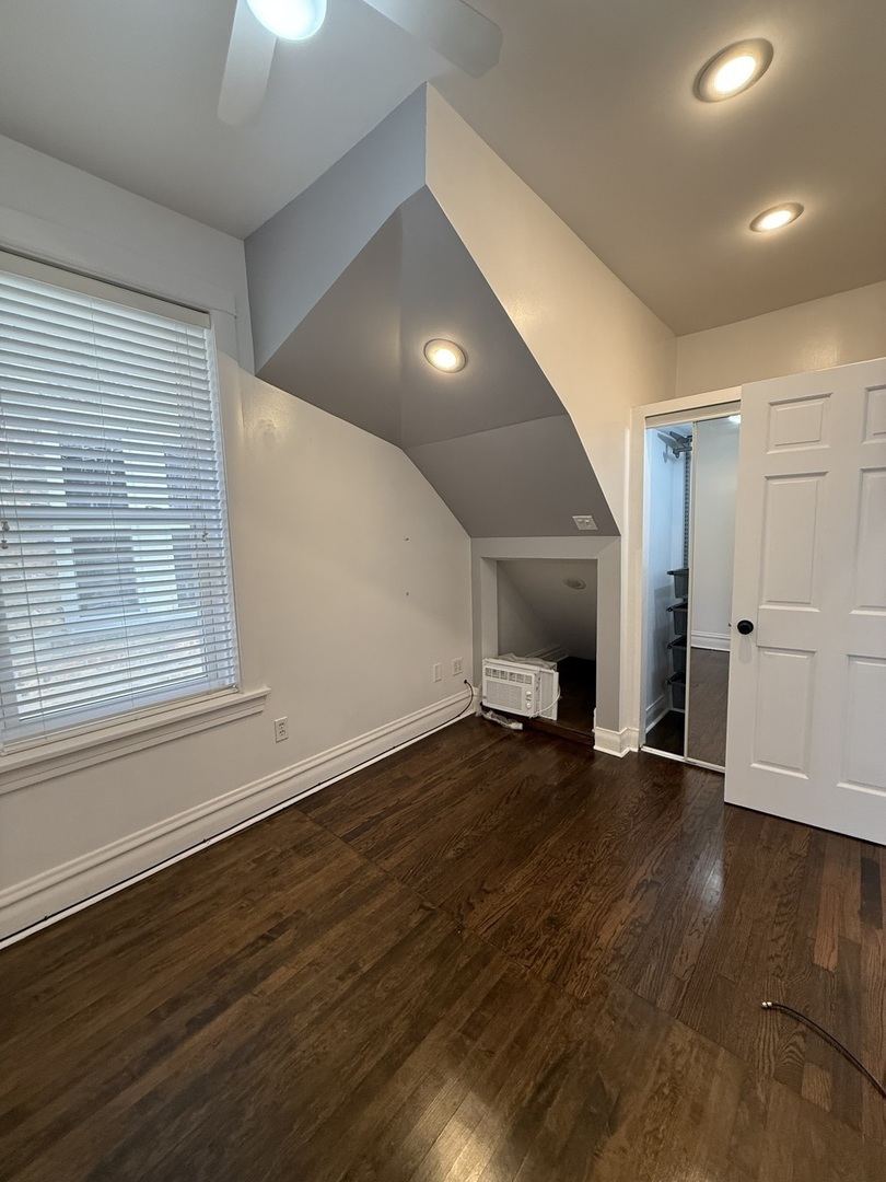 3721 West Belden Avenue, Unit 1 Chicago, IL 60647 - Photo 20 of 23 an empty room with wooden floor and fireplace