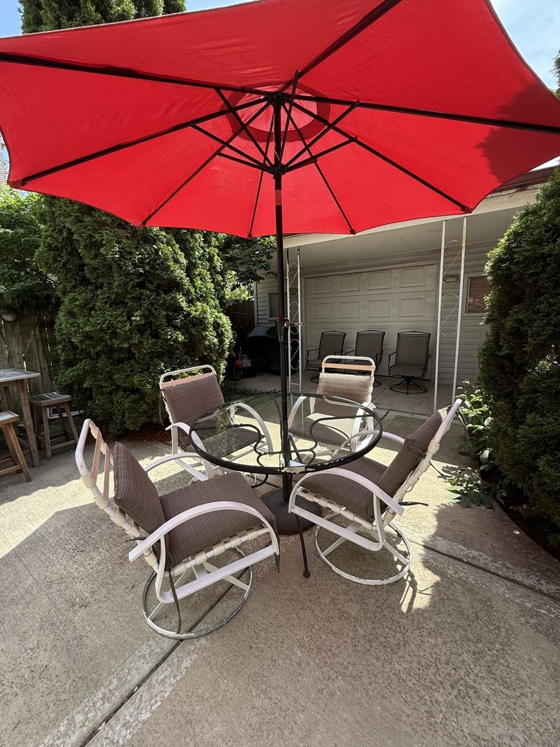 3721 West Belden Avenue, Unit 1 Chicago, IL 60647 - Photo 3 of 23 a view of a patio with lawn chairs under an umbrella