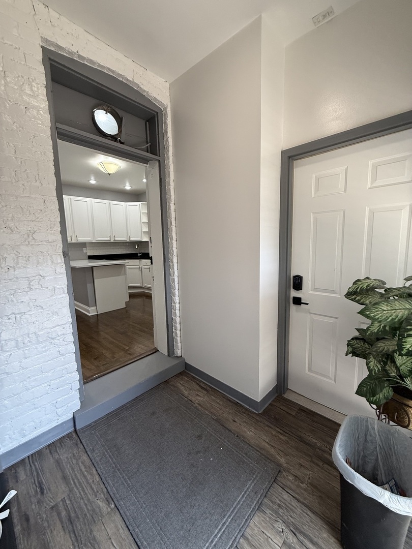 3721 West Belden Avenue, Unit 1 Chicago, IL 60647 - Photo 10 of 23 a room with a chair and potted plant with wooden floor