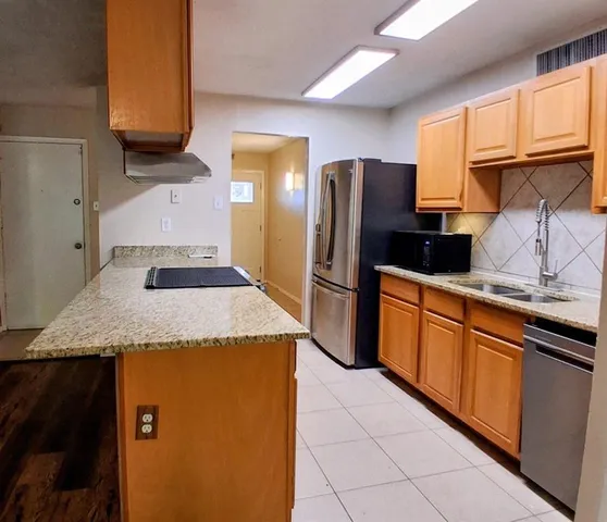a kitchen with stainless steel appliances granite countertop a refrigerator and a sink