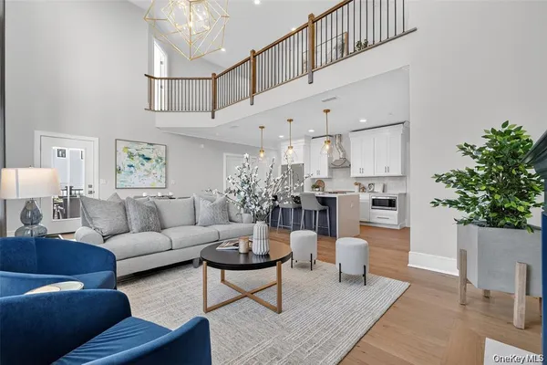a living room with furniture kitchen view and a potted plant