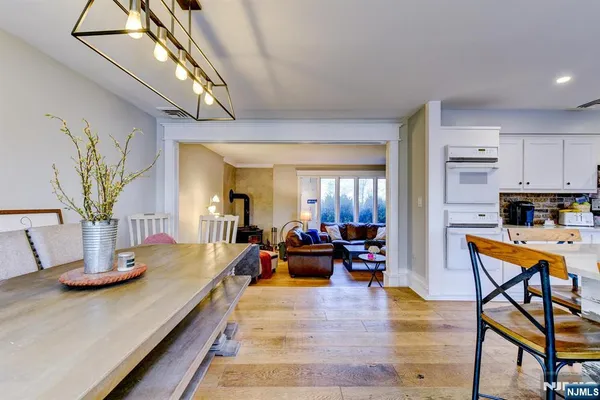 a living room with furniture kitchen view and a wooden floor