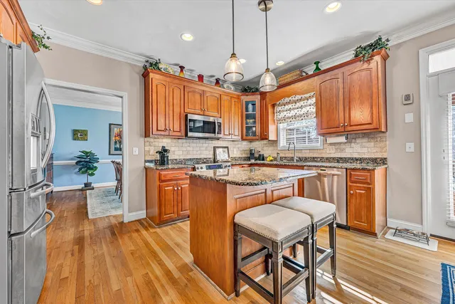 a kitchen with stainless steel appliances granite countertop a refrigerator and a stove top oven