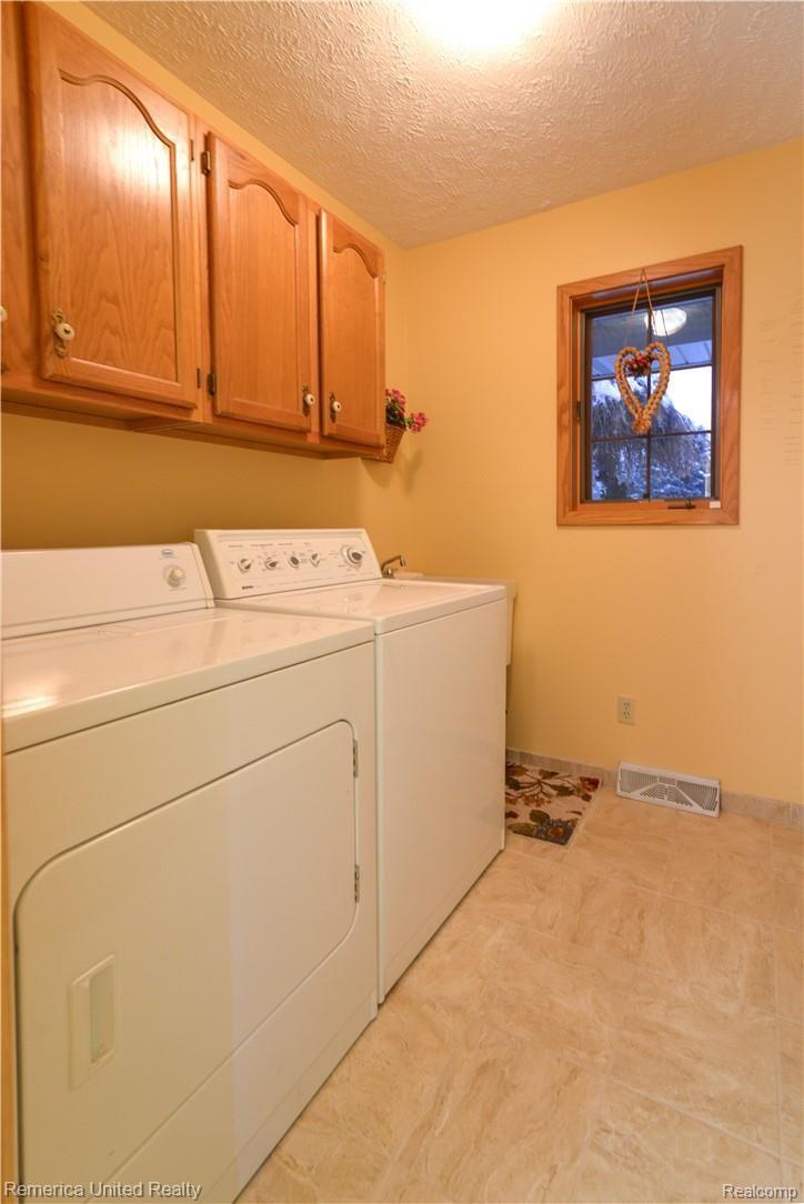 12264 Raelyn Hills Drive Perry, MI 48872 - Photo 35 of 46 First Floor Laundry With Ceramic Tile