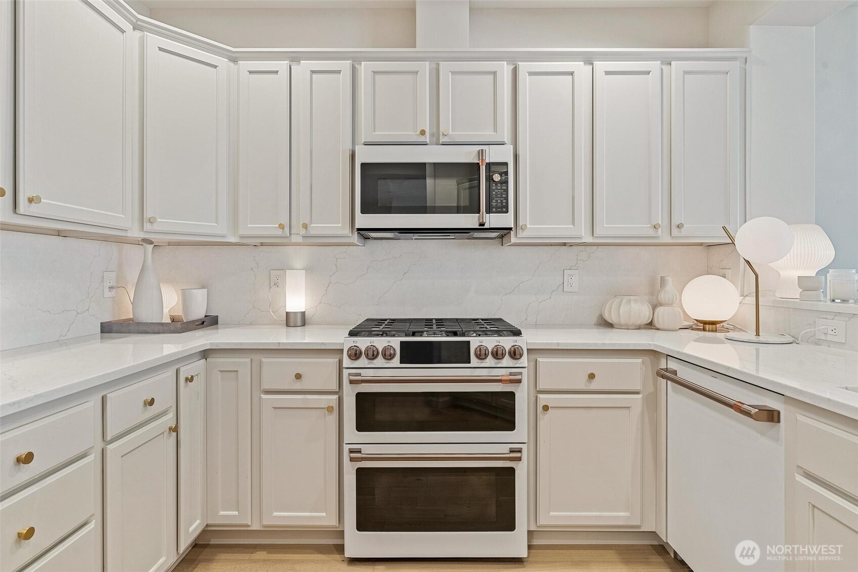 8502 Main Street, Unit E105 Edmonds, WA 98026 - Photo 12 of 39 a kitchen with white cabinets and stainless steel appliances